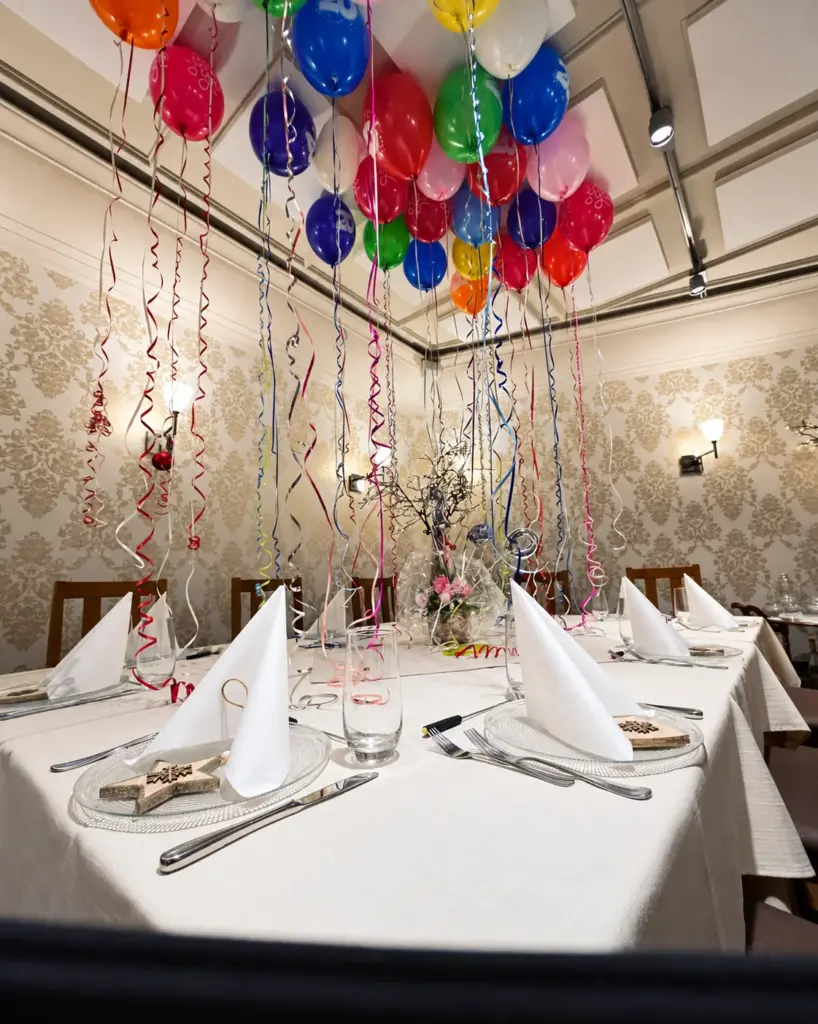 Salle de fête avec ballons colorés au plafond