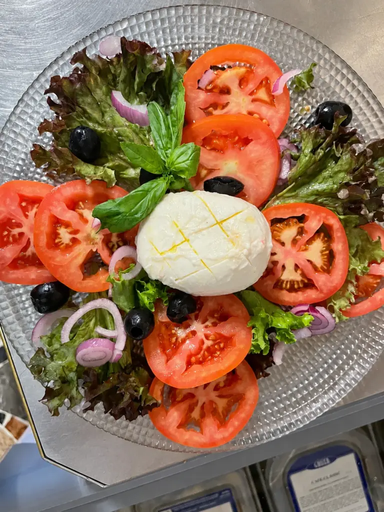 Caprese mit Mozzarella, Tomaten, Oliven und Basilikum