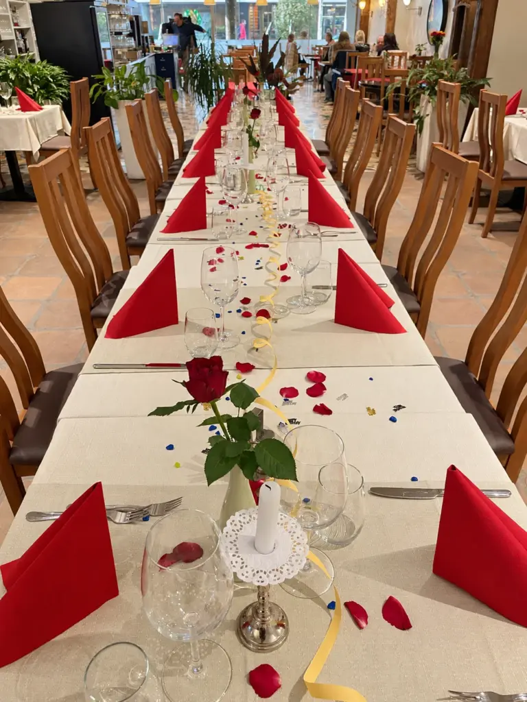 Longue table de fête avec roses et serviettes rouges