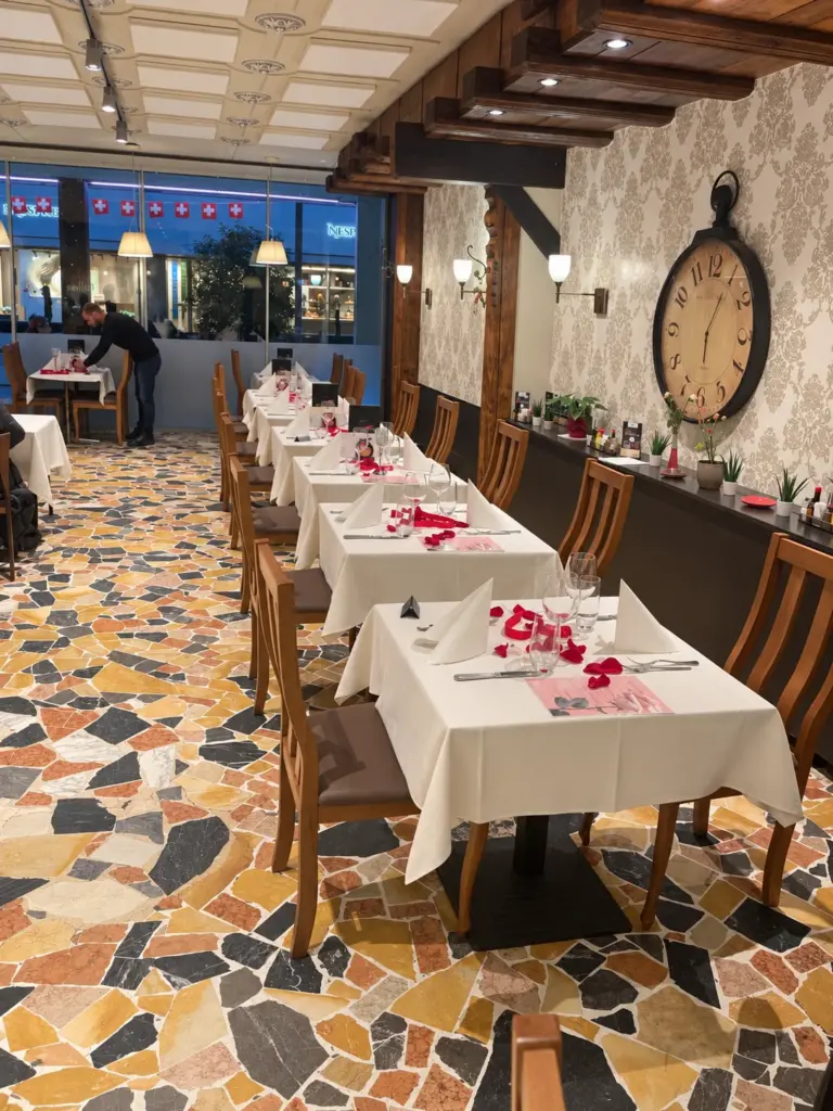 La salle avec ses tables dressées et sa grande horloge