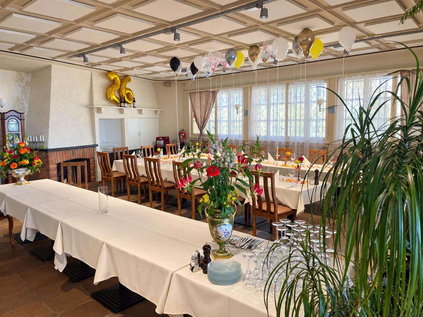 Salle dressée pour une fête, avec fleurs et ballons